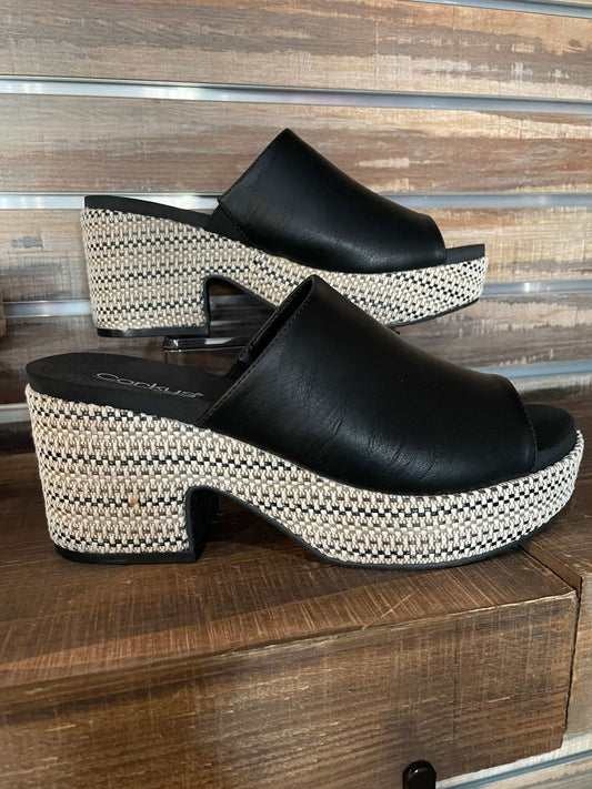 Black chunky heeled wedge sandal with 3.25-inch heel and 1-inch platform, featuring raffia-wrapped sole.