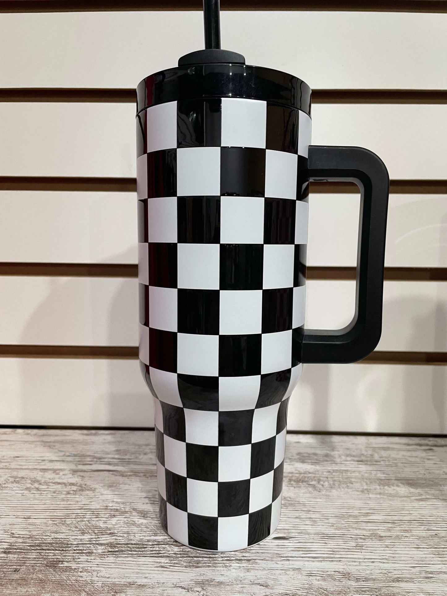 Black and white checkered tumbler with insulated design for keeping drinks cool in style