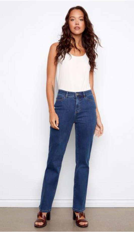 Woman wearing a white top and blue jeans against a white background