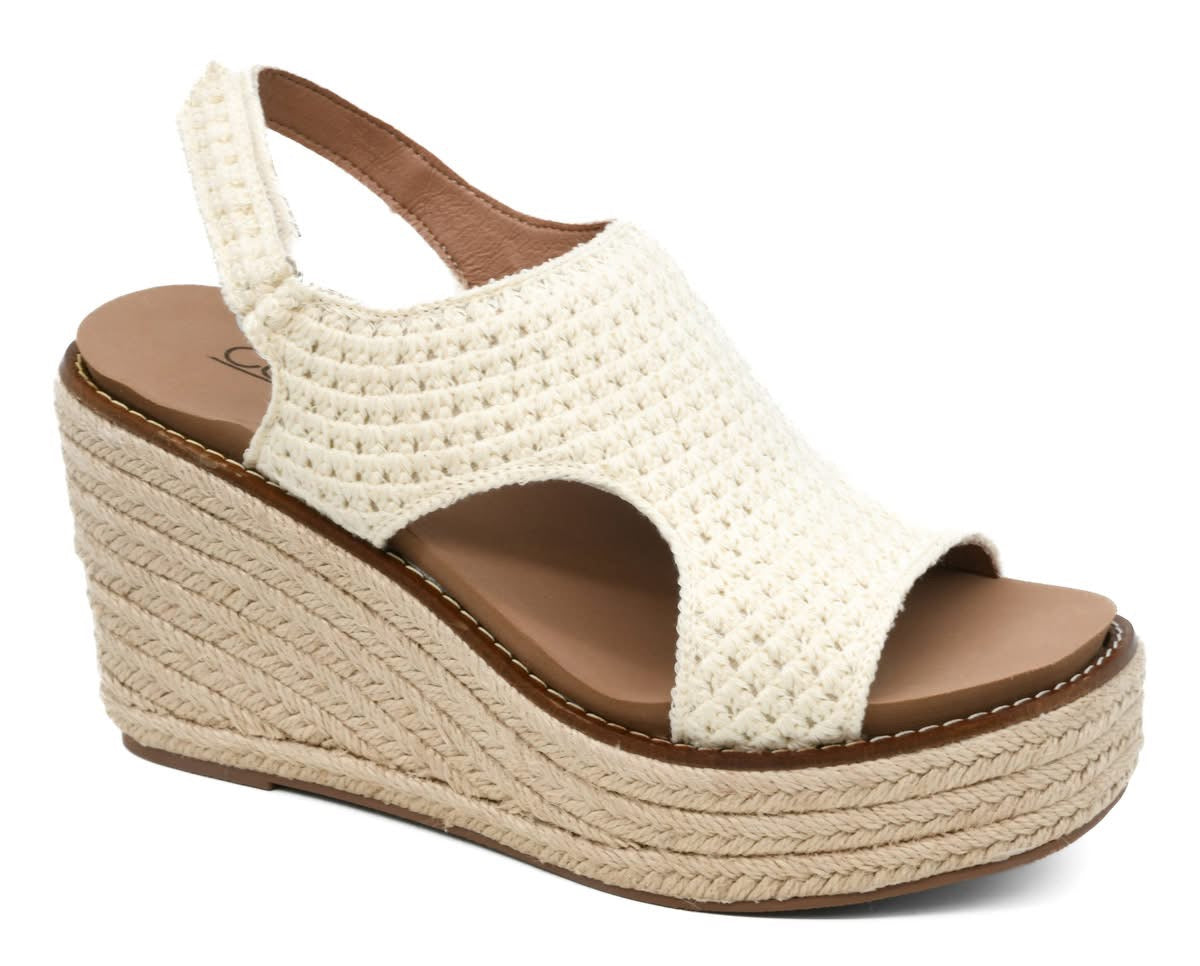 White wedge sandal with brown sole on a white background