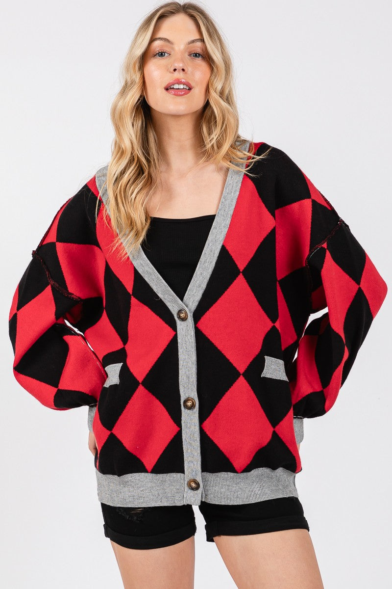 Woman wearing a red and black diamond pattern cardigan with gray trim on a white background