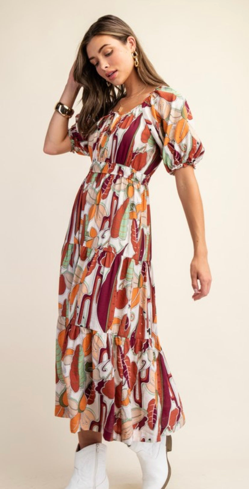 Woman wearing a fall patterned dress on a beige background