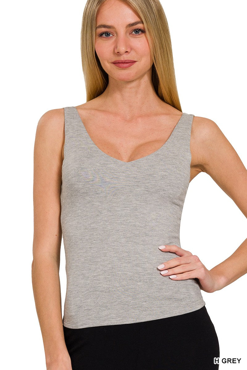 Woman wearing a gray tank top against a white background