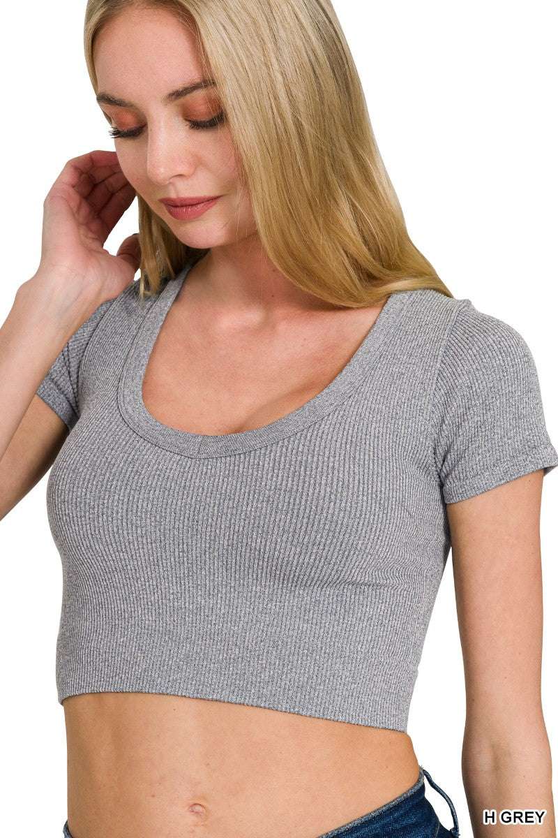 Woman wearing a gray ribbed crop top on a white background