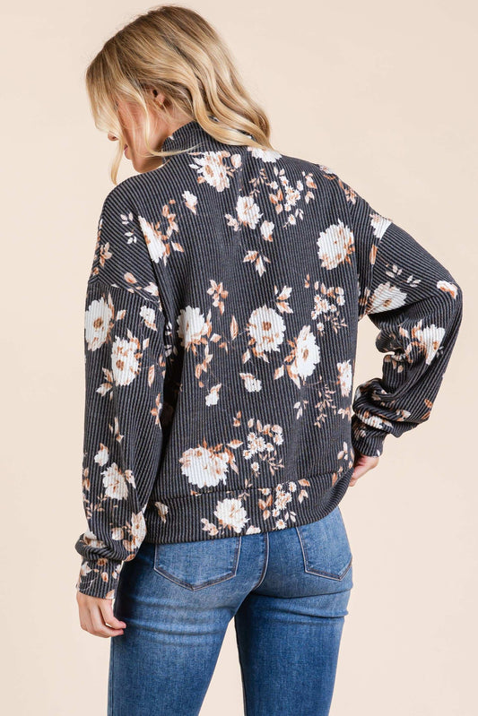Woman wearing a floral patterned shirt with a neutral background