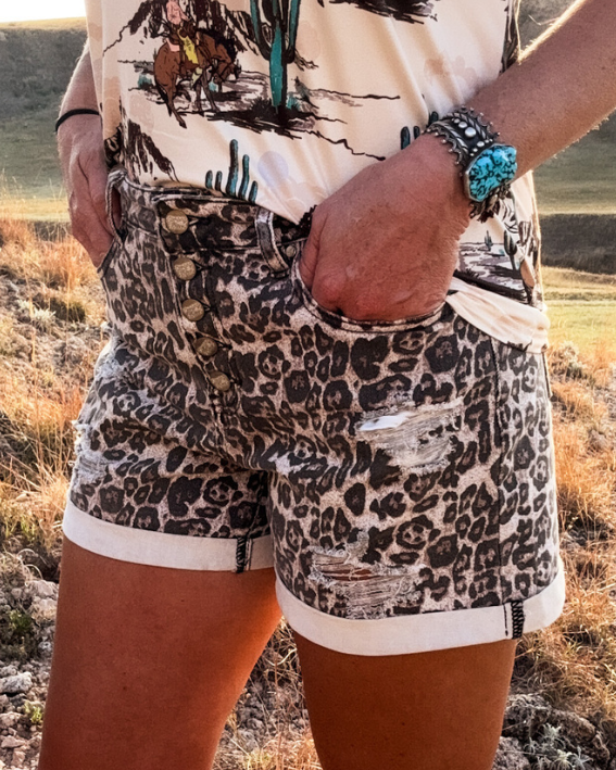 Person wearing leopard print shorts with a scenic background