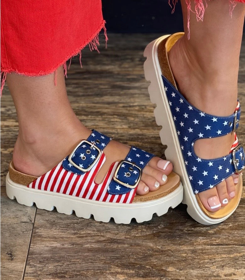 Flag-patterned sandals on a wooden floor