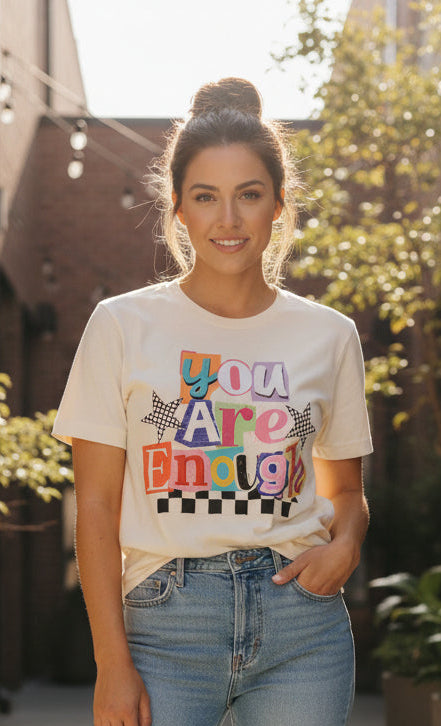 Beige sweatshirt with colorful text design on a textured surface