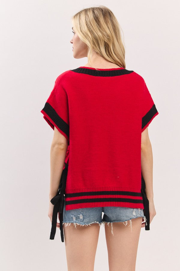 Woman wearing a red top with black trim on a white background