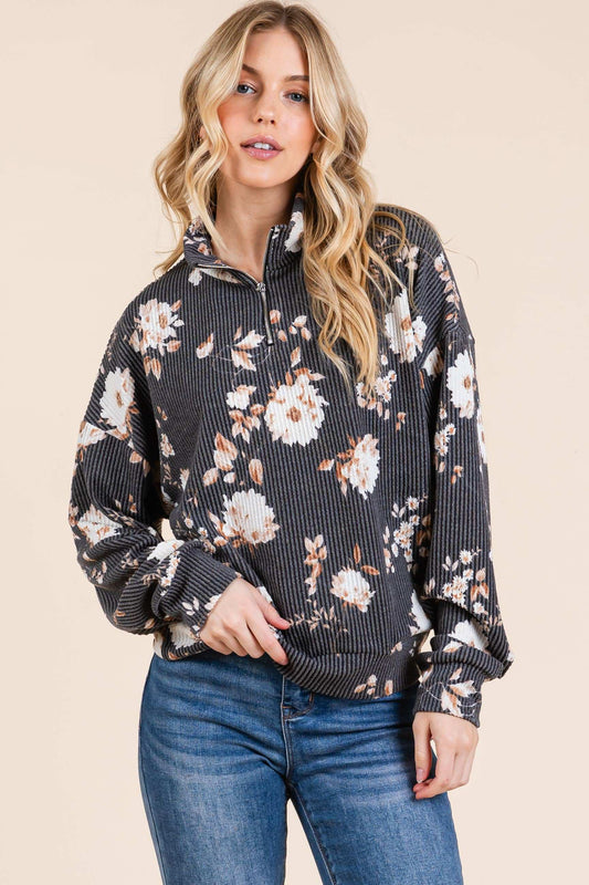 Woman wearing a floral patterned sweater with a neutral background