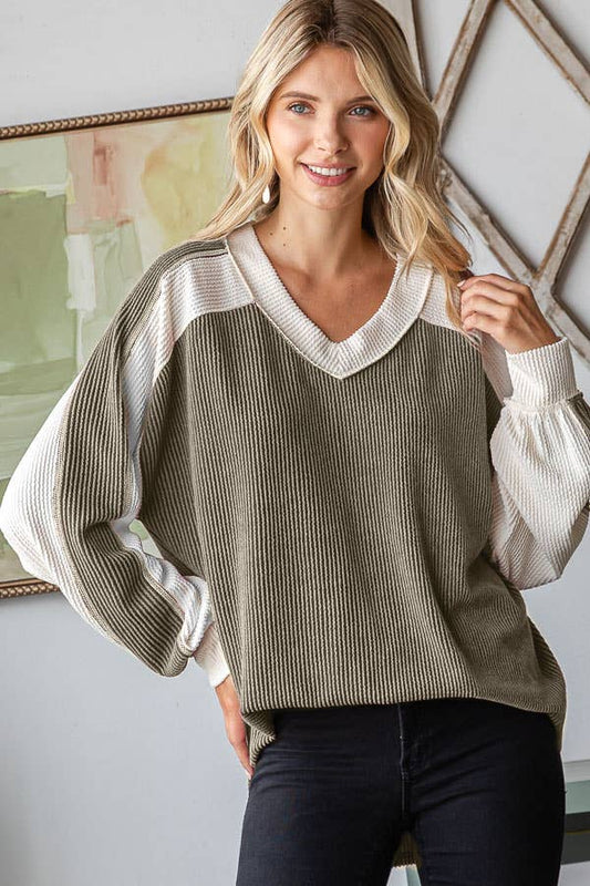 Woman wearing a green and white sweater with a blurred background